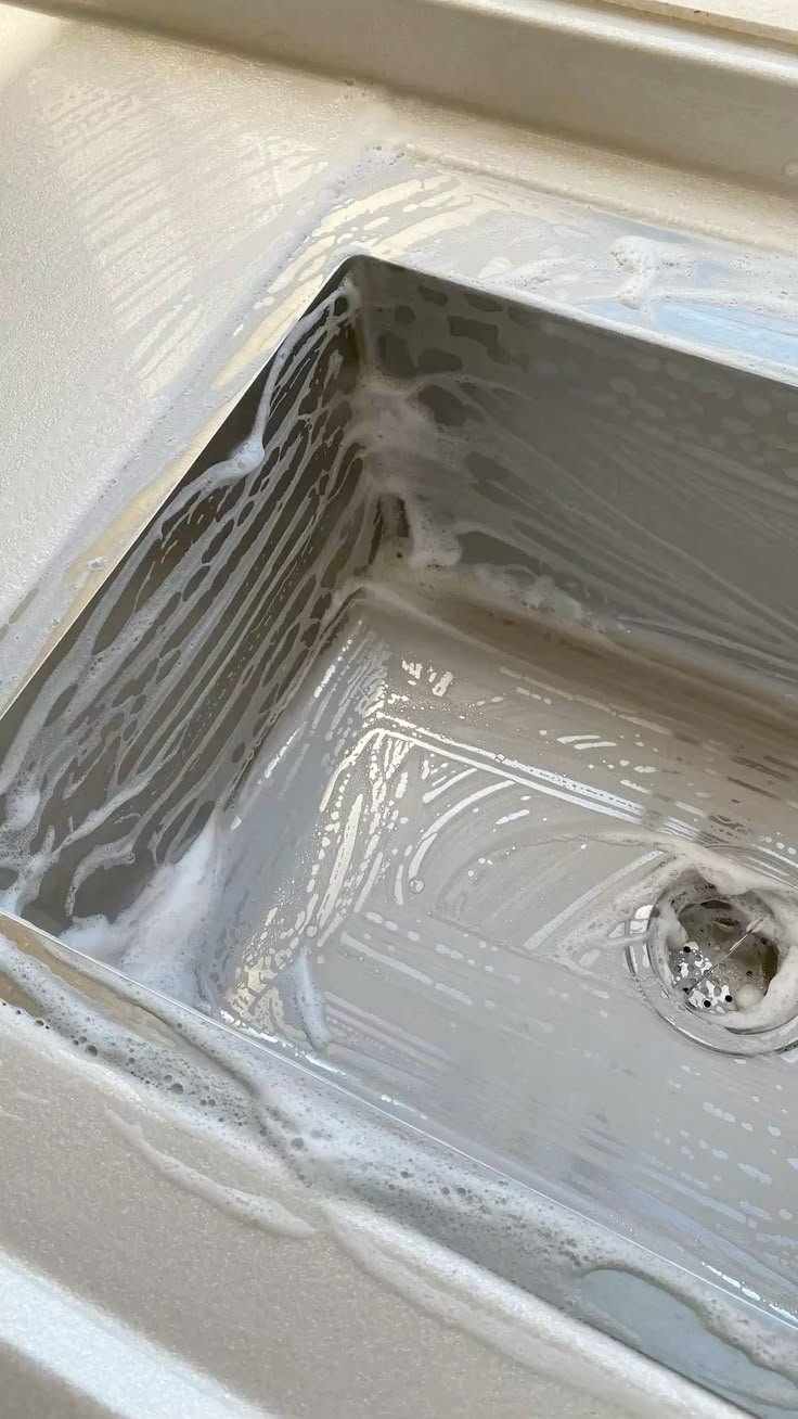 Sink being scrubbed with soap suds